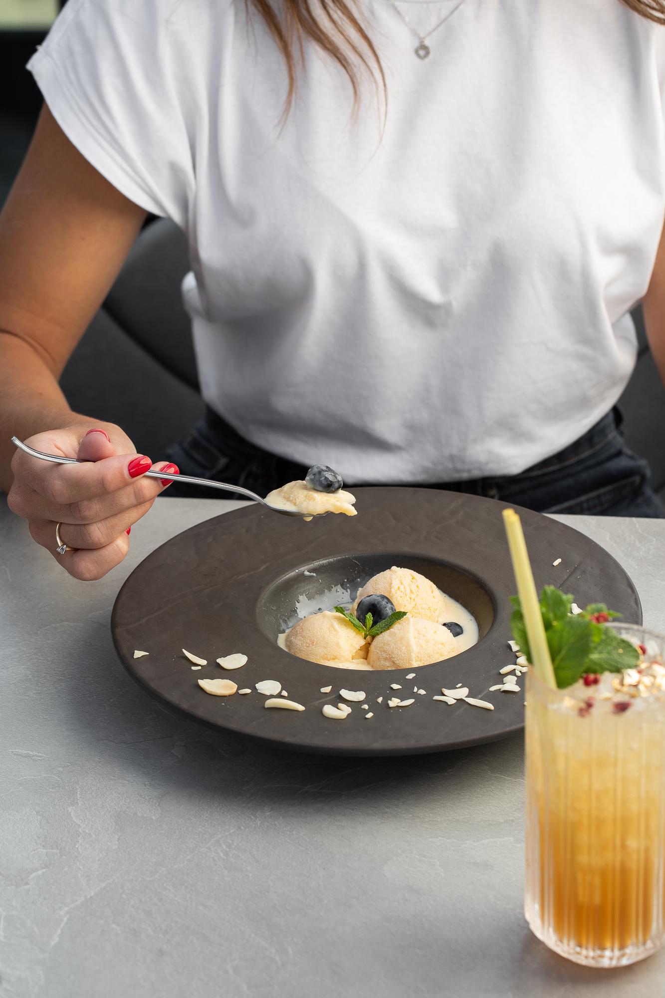 Editorial shot of a chef plating a dish in soft monochrome