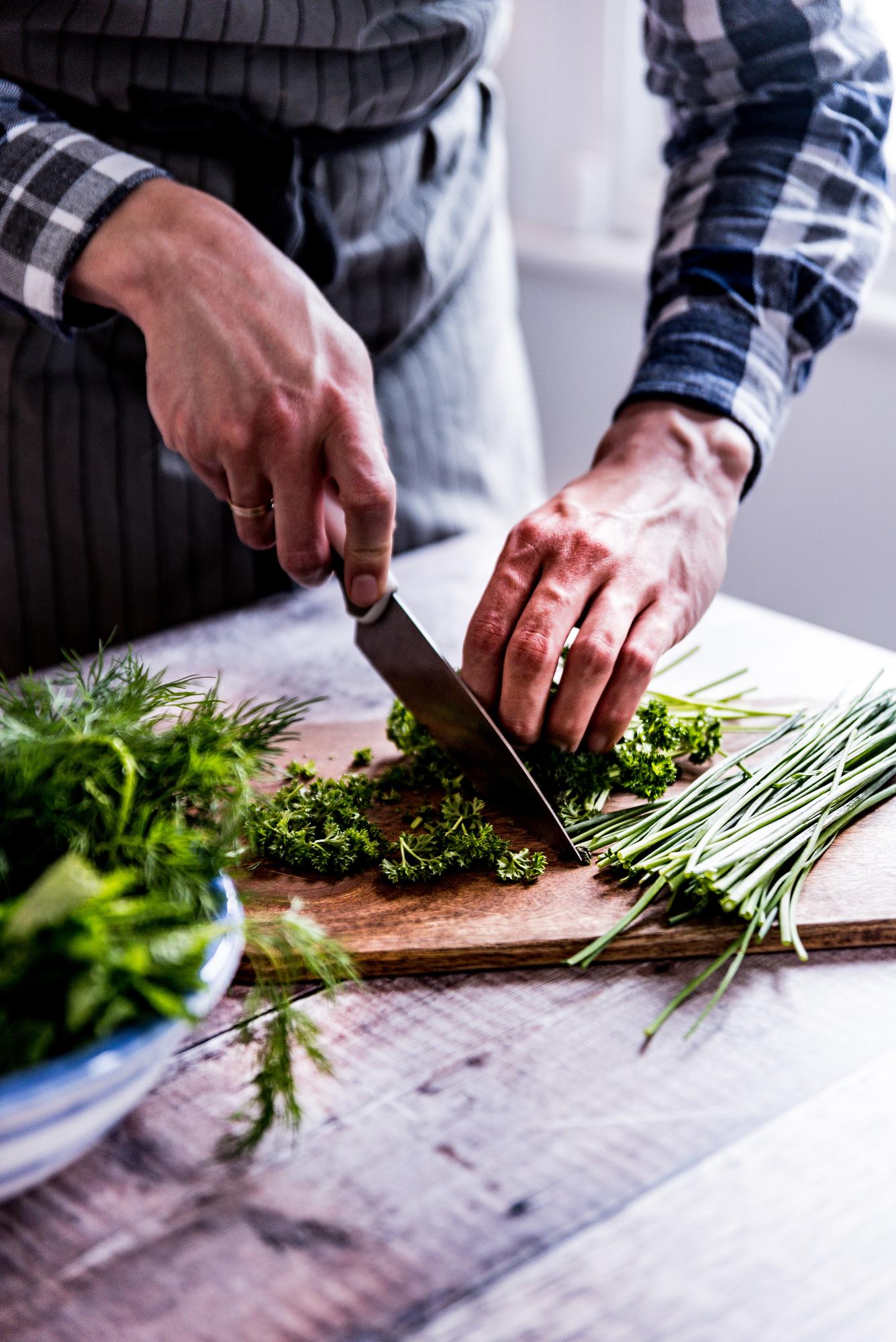 Close-up of hands chopping herbs